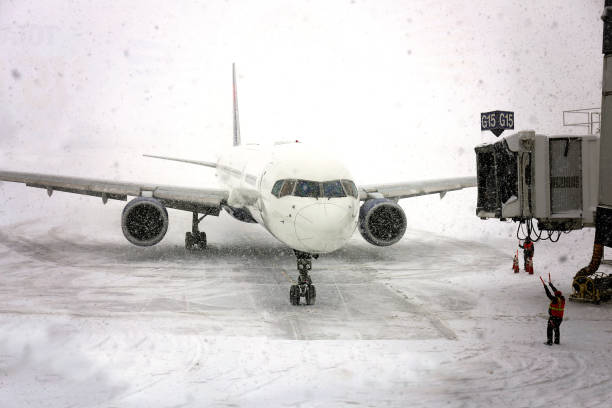 istock Commercial Jet Airplane Pulling up to Gate in Blizzard Snowstorm 1131299020