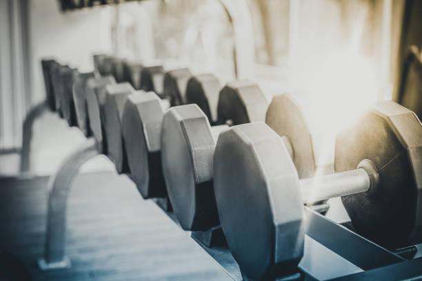 istock Dumbbells on rack in fitness center. 1131299279