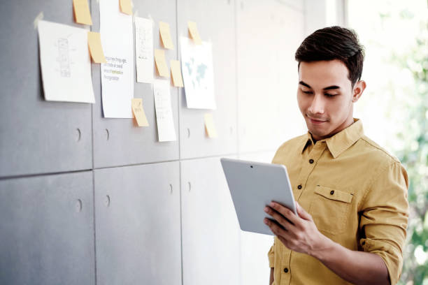 istock Young Asian Businessman Working on Digital Tablet in Office Meeting Room. Man Analyzing Data Plans and Project 1131302536