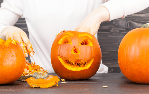 istock Woman cut out a pumpkin 1131303540