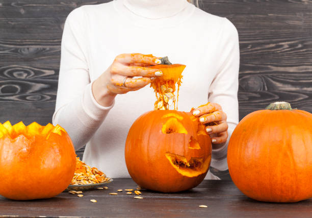 istock Woman cut out a pumpkin 1131303545