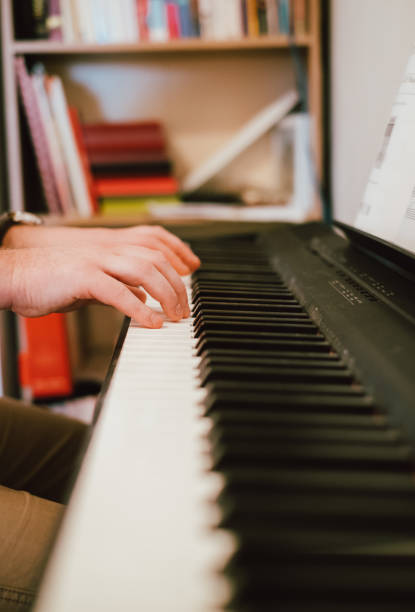 istock Hands of a man playing piano at home 1131303631