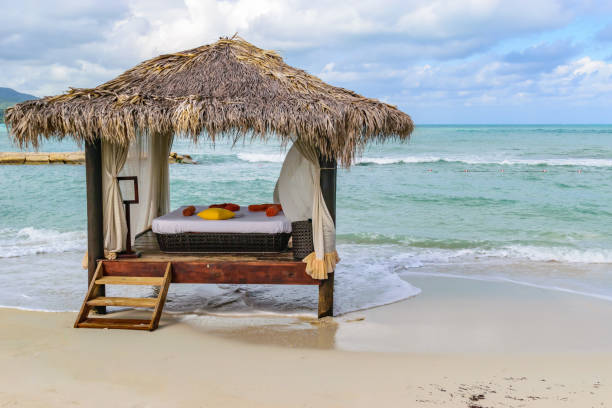 istock Thatch roof hut massage bed on tropical island white sand beach 1131305596