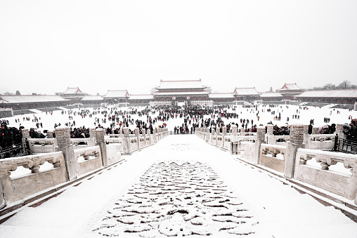 Beijing,China-Februaru 12, 2019: Crowd tourists in the square of Forbidden City enjoy the rare snowing