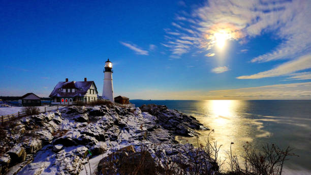 снежная луна восстание на портленд-хед маяк после снега 2019 - maine lighthouse winter ice стоковые фото и изображения