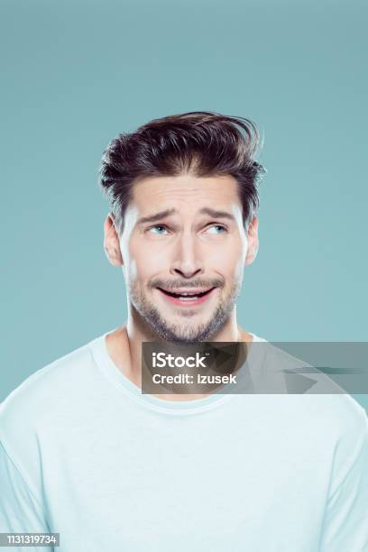 Confused Young Man Looking Away Stock Photo - Download Image Now - Men, Confusion, Grimacing