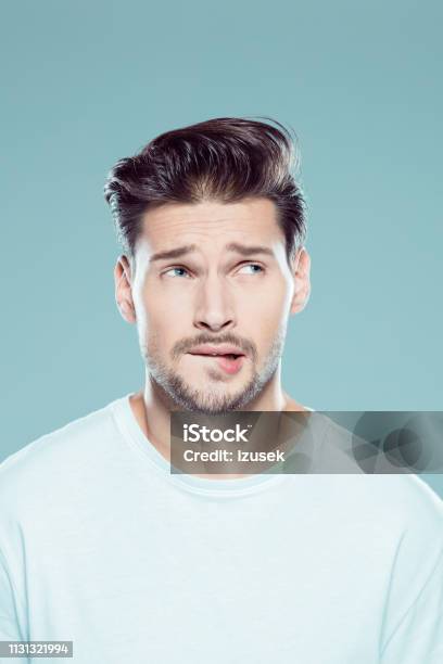 Nervous Young Man Looking Away Stock Photo - Download Image Now - Biting Lip, Men, Portrait