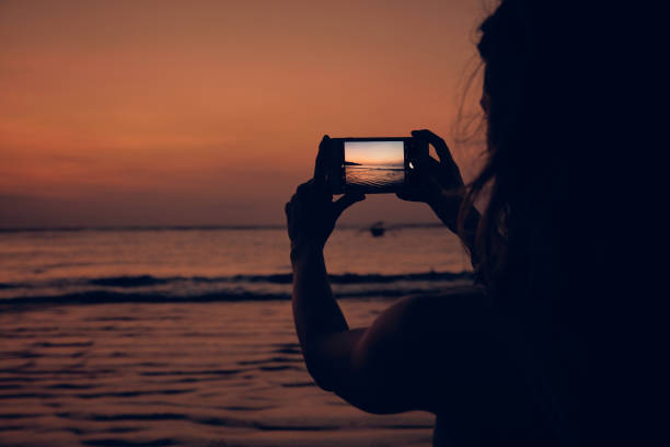 istock Woman using cellphone on a tropical ocean beach. 1131330263