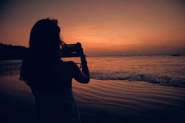 istock Woman using cellphone on a tropical ocean beach. 1131330316