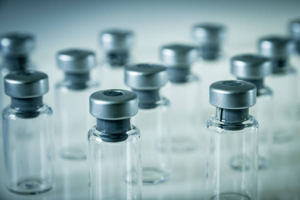 istock Vaccine glass bottles on grey background 1131330350