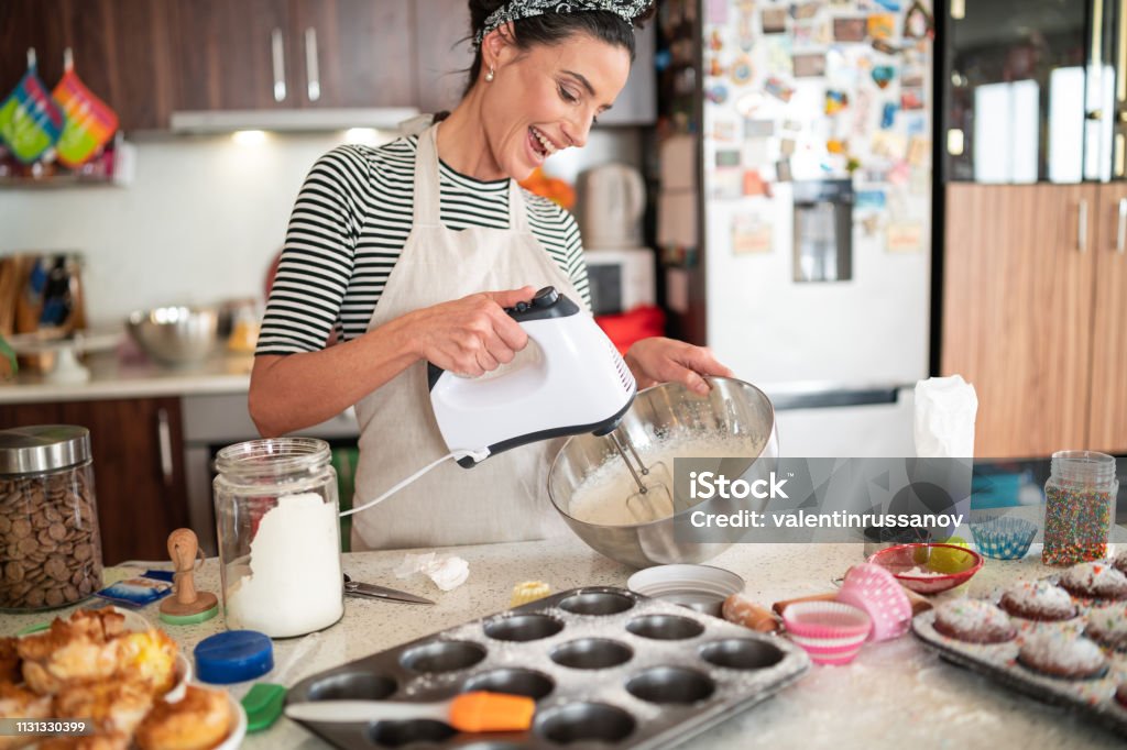 Confectioner woman making delicious cream for cupcakes Baking Stock Photo