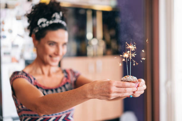 Confectioner holding birthday cupcakes