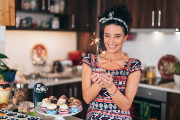 Confectioner holding birthday cupcakes