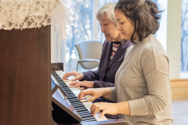 azjatyckie babcia i mieszane etniczne wnuczka gra na fortepianie duet razem - muzykoterapia zdjęcia i obrazy z banku zdjęć