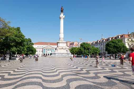 Lisbon, Portugal - September 30, 2018: View of the Rossio Square with tourists walking by, in the pombaline downtown of the city of Lisbon, Portugal