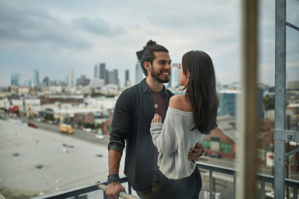 istock Romantic couple standing in balcony against city 1131333507