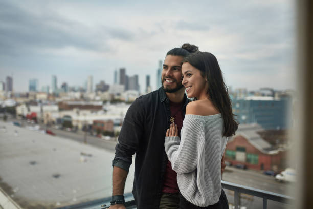 istock Smiling couple standing in balcony against city 1131333543