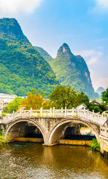 piccolo ponte sull'acqua e cime verdi a yangshuo, provincia del guangxi, cina - bridge beauty in nature travel destinations yangshuo foto e immagini stock