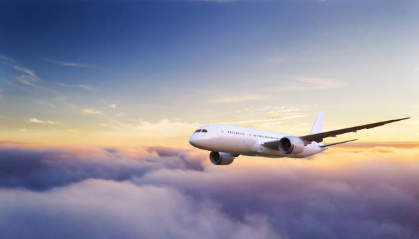 Beautiful sunrise cloudy sky from aerial view Huge two-storey passengers commercial airplane flying above clouds in sunset light. Concept of fast travel, holidays and business. jet stock pictures, royalty-free photos & images