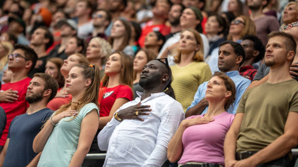 Spectators singing national anthem in stadium