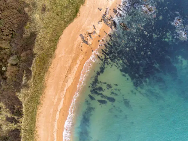 This is an aerial photograph of Kinnageo Beach on the Inishowen peninsula in Donegal Ireland.  It shows the crystal clear turquoise water of the Atlantic Ocean