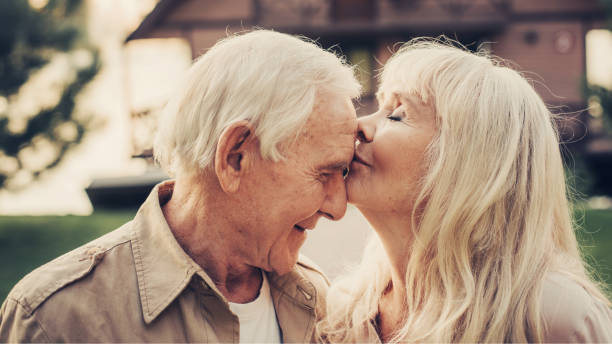Elderly grey haired woman caressing to man