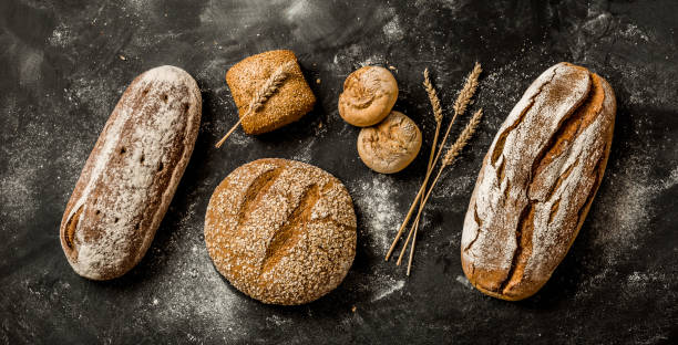 istock Bakery - rustic crusty loaves of bread and buns on black 1131340884