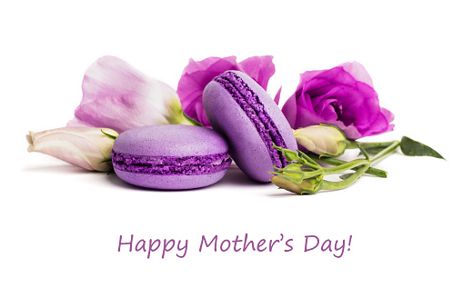 Cake macaron or macaroon isolated on white, violet almond cookies, pastel colors, violet spring flowers with text Happy Mother's Day.