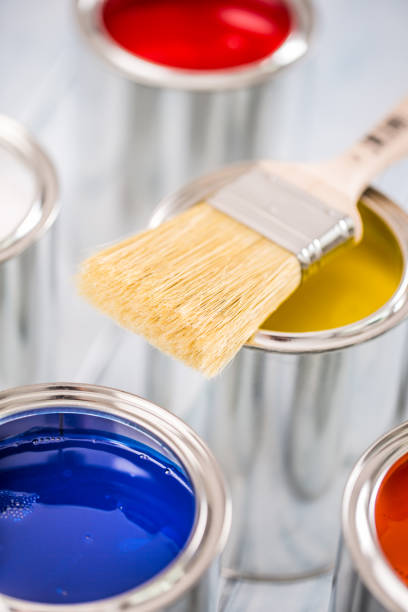 istock Close-up brush lying on multicolored paint cans. 1131342785
