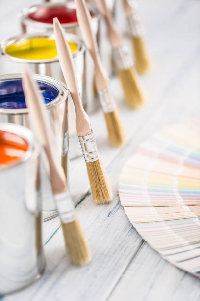 istock Paint cans brushes and color palette on table. 1131342807