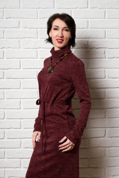 istock Beautiful woman posing near white brick wall background 1131343657