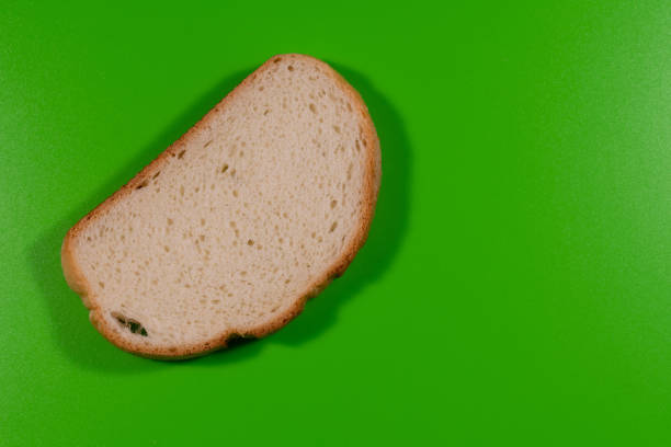 a piece of white bread on a green table close-up. delicious pastries.