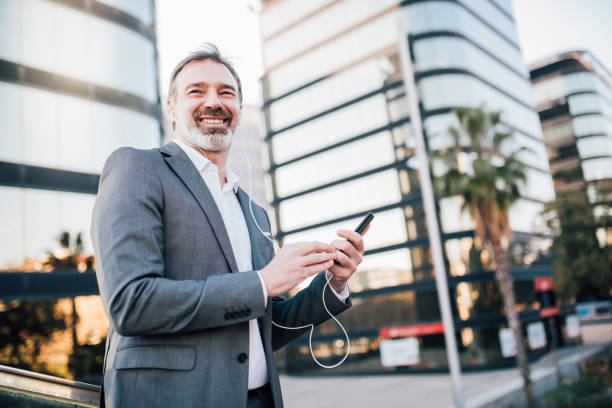 istock Smiling man with headphones and mobile phone 1131345113