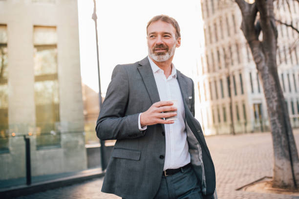 istock Man holding cup of coffee 1131345541