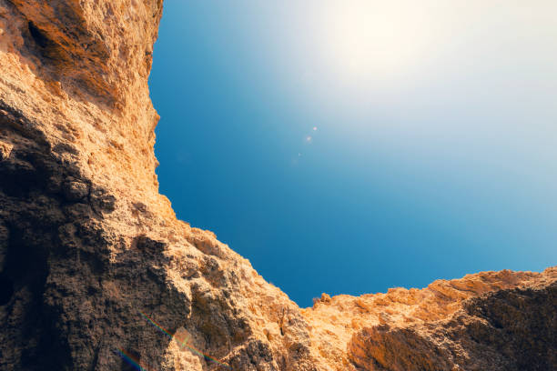 This image captures the stark beauty of white rock formations under a cloudless, vibrant blue sky. The sharp contrast between the rocky textures and the deep blue background emphasizes the rugged grandeur of nature's formations.