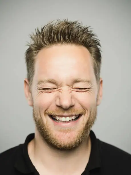 Photo of Portrait of real caucasian man with excited expression and closed eyes