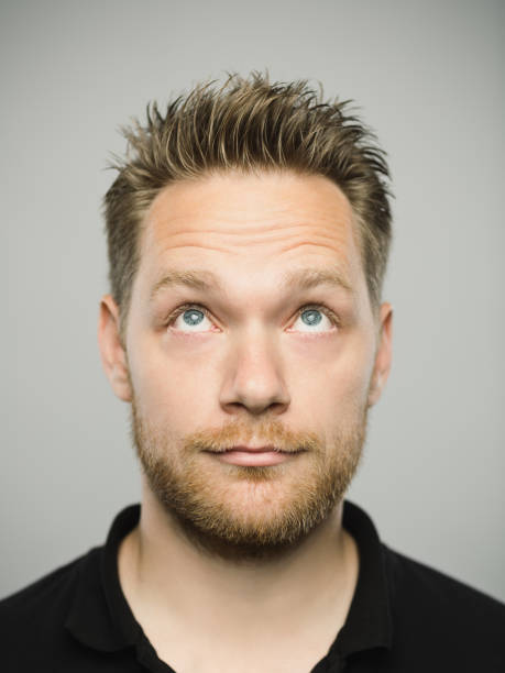istock Portrait of real caucasian man with blank expression looking up 1131350992