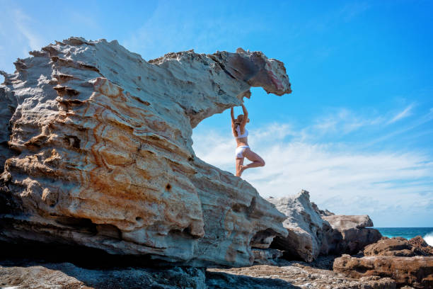 istock Woman standing in a remote stunning shaped sandstone overhang 1131351713