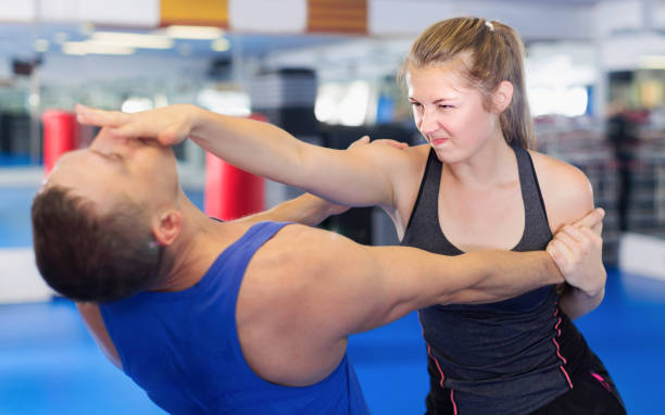 istock Fitness woman and her trainer are exercise punches 1131352104