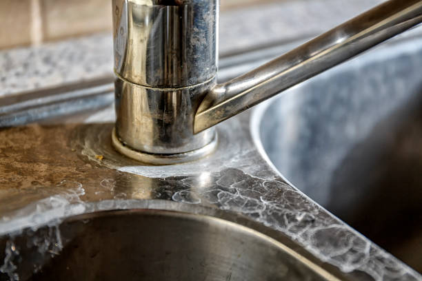 Close-up of a kitchen sink with lime scale Close-up of a kitchen tap and sink with hard water calcification. limestone stock pictures, royalty-free photos & images