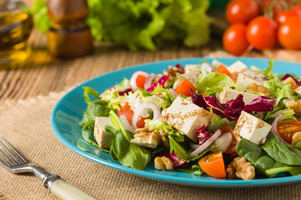 istock Delicious salad with tofu, tomatoes and walnuts. 1131356895