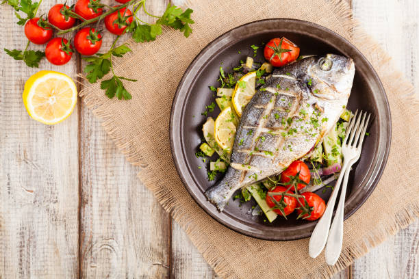 istock Baked whole fish, served with roasted vegetables and lemon. 1131357495