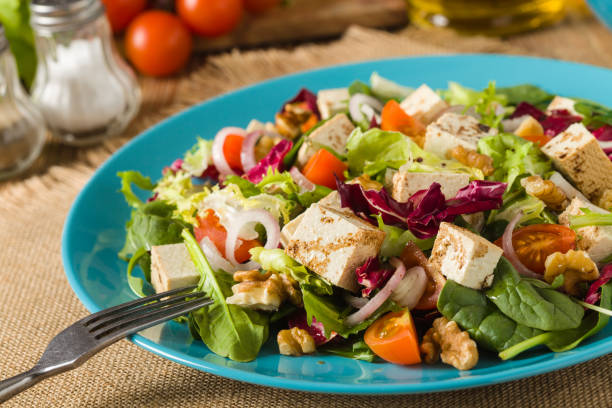 istock Delicious salad with tofu, tomatoes and walnuts. 1131357932