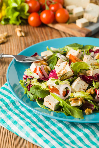 istock Delicious salad with tofu, tomatoes and walnuts. 1131357992