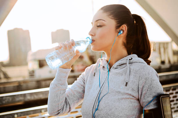 istock Sporty young woman runner taking a break hydrating 1131358018