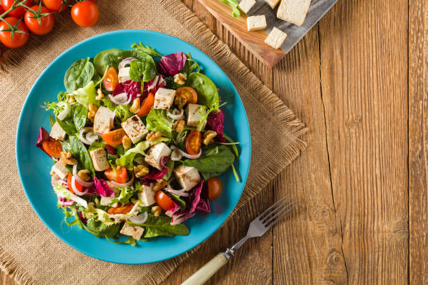 istock Delicious salad with tofu, tomatoes and walnuts. 1131358083
