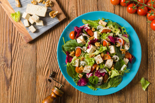 istock Delicious salad with tofu, tomatoes and walnuts. 1131358272