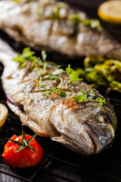istock Grilled whole fish, served with roasted vegetables and lemon. 1131358311