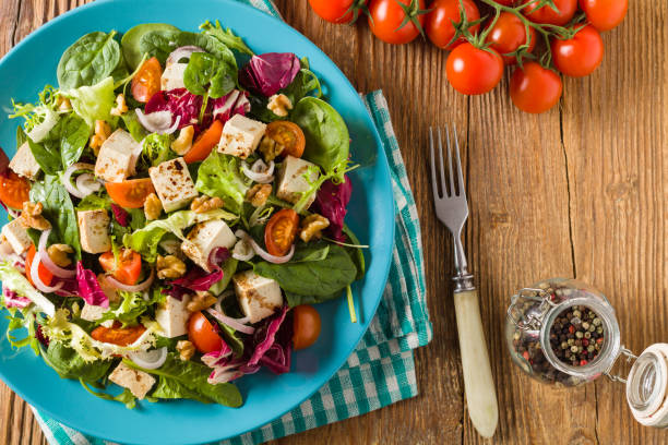 istock Delicious salad with tofu, tomatoes and walnuts. 1131358411