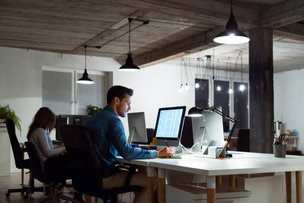 Businessman using computer by female colleague